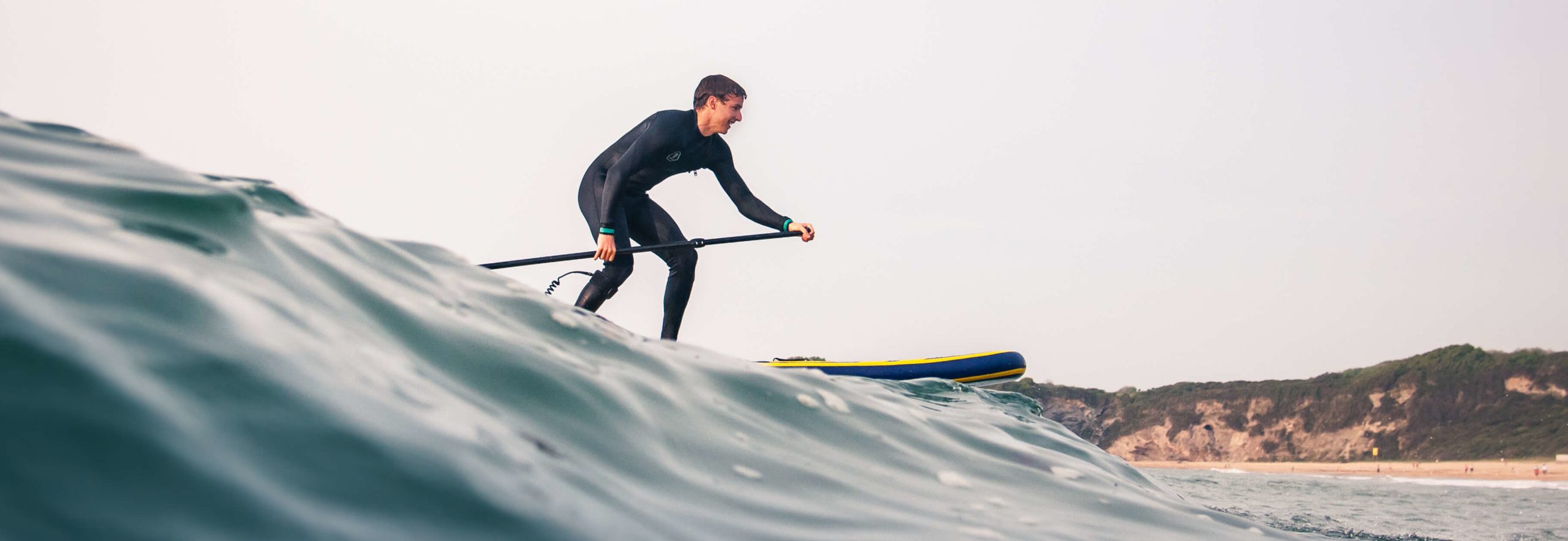 Jeune homme en train de surfer en stand up paddle, comment bien choisir son sup