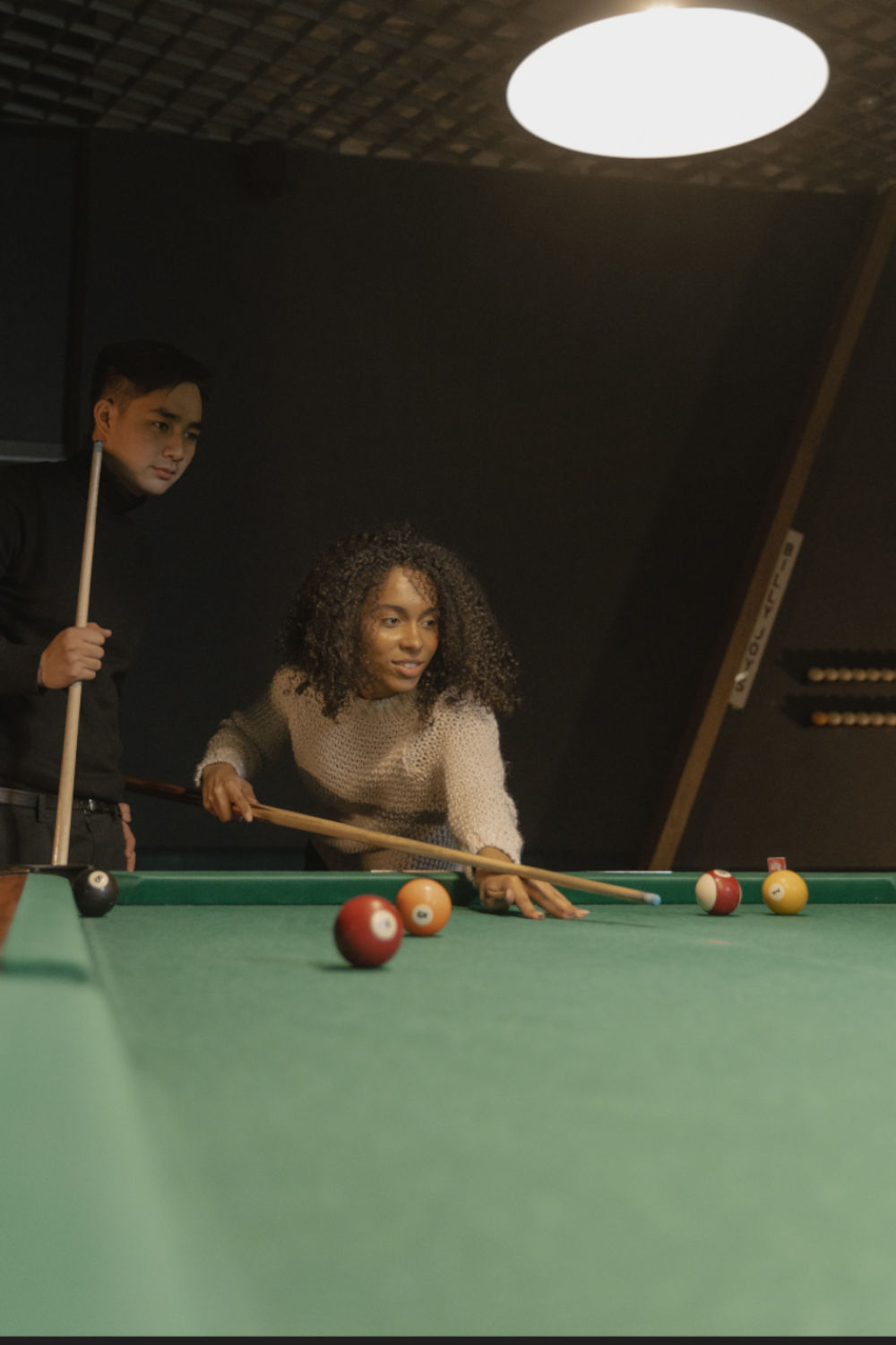 Couple jouant au billard.