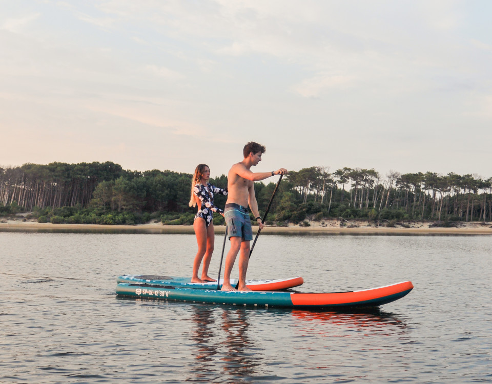 Jeune gens profitant d'une douce soirée automnale pour faire une sortie de paddle.