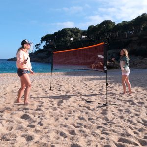 2 femmes jouant au badminton avec le filet multisport sur la plage